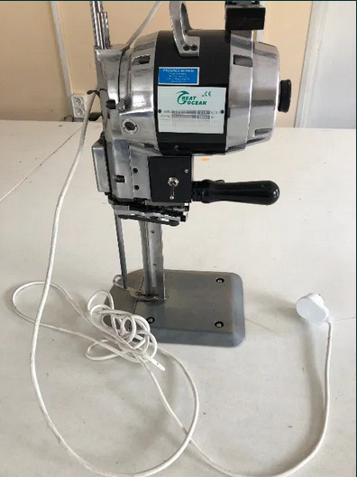 Elektryczny nóż krojczy marki Great Ocean, stojący na białym stole z widocznym kablem zasilającym i wtyczką.