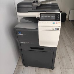 Copix Sp z o.o. - Używana kserokopiarka Konica Minolta bizhub C3350i w biurowym otoczeniu, widoczny panel dotykowy i szuflada na papier.