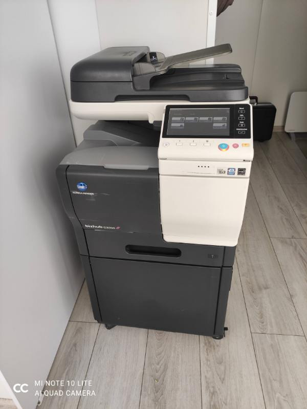 Używana kserokopiarka Konica Minolta bizhub C3350i w biurowym otoczeniu, widoczny panel dotykowy i szuflada na papier.