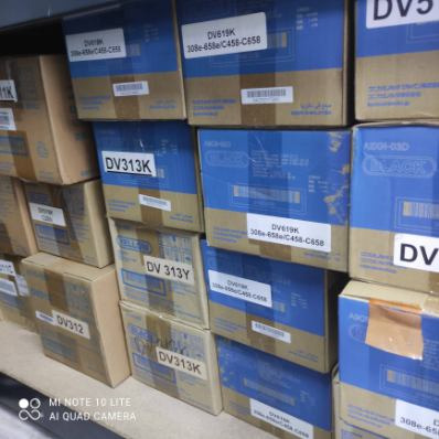 Stos kartonowych pudełek z tonerami do kserokopiarek, różne modele i numery seryjne widoczne na etykietach.