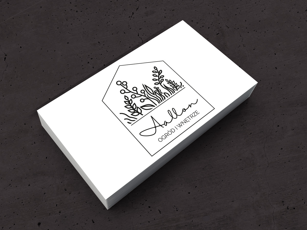 Stos wizytówek z minimalistycznym logo firmy 'Aallon Ogród i Wnętrze' z motywem roślinnym, na ciemnym, teksturowanym tle.