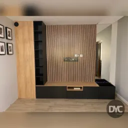 Nowoczesna zabudowa ściany telewizyjnej z drewnianymi lamelami, czarnymi szafkami i półkami, oraz elementami z jasnego drewna, uzupełniona o ramki ze zdjęciami na ścianie.
