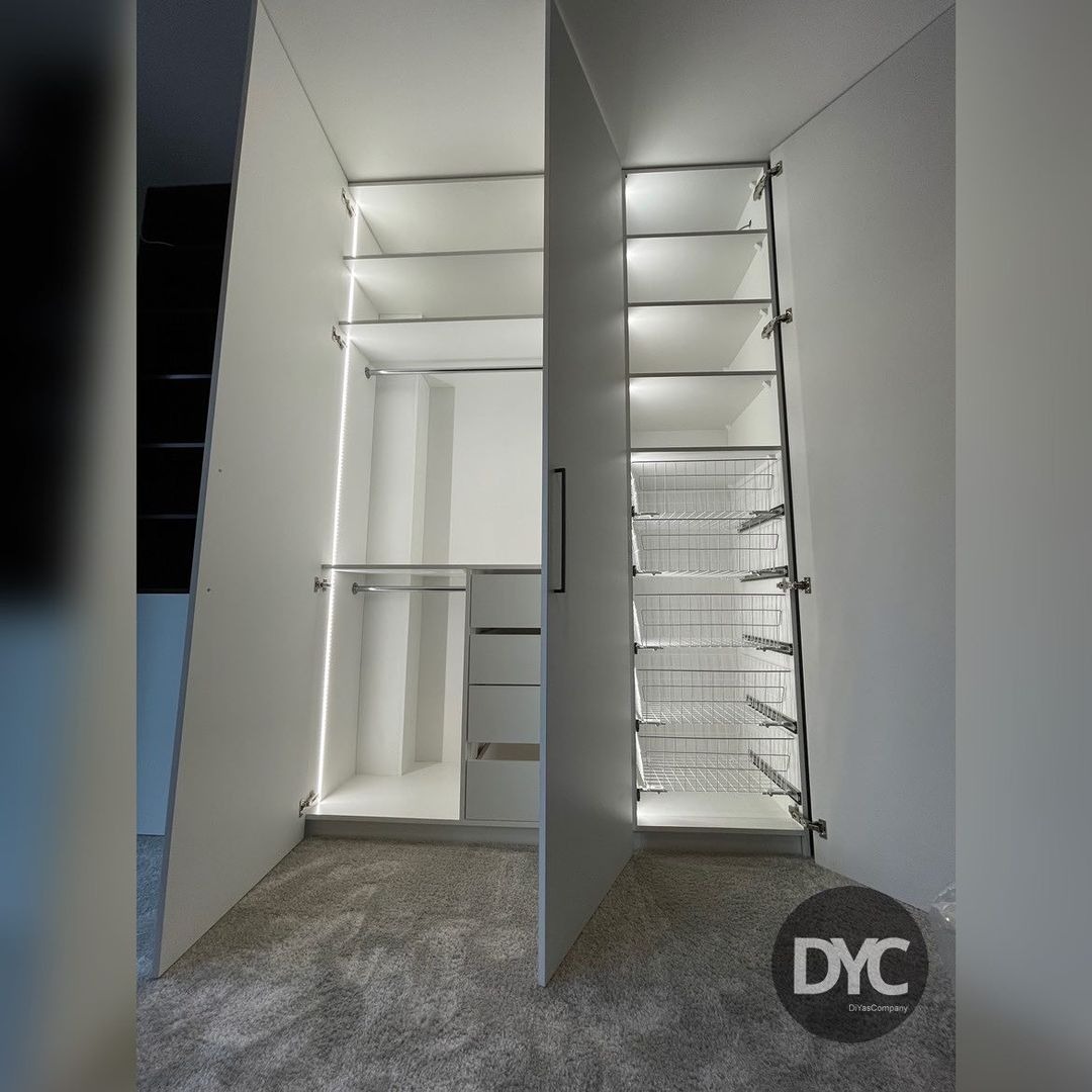 Otwarta, biała szafa z oświetleniem LED i wysuwanymi koszami w Poznaniu, widok na półki, drążki i szuflady.