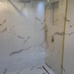 Ścianka walk-in w złotych okuciach.