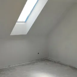 Pokój na poddaszu ze świeżo położonymi, jasnoszarymi tynkami i posadzką, widoczne okno dachowe zabezpieczone folią malarską oraz wystający przewód elektryczny.