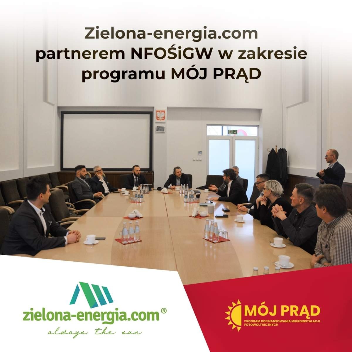 Spotkanie partnerów programu Mój Prąd z logotypami Zielona-energia.com i Mój Prąd w dolnych rogach zdjęcia.