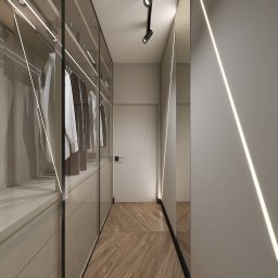 Natalia Korczyńska - Nowoczesna garderoba z przeszklonymi drzwiami, oświetleniem LED i drewnianą podłogą. Minimalistyczny design, jasne kolory, punktowe oświetlenie sufitowe.