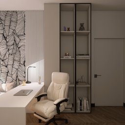 Natalia Korczyńska - Nowoczesny pokój z biurkiem, krzesłem i regałem. Na ścianie tapeta w liście i paski. Laptop na blacie. Stonowana kolorystyka i oświetlenie.