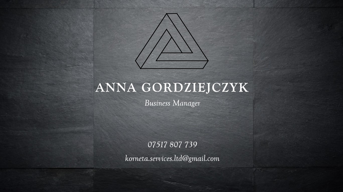 Wizytówka z imieniem Anna Gordziejczyk, tytułem Business Manager, numerem telefonu i adresem e-mail, umieszczona na tle z ciemnej, teksturowanej płyty imitującej łupek, z abstrakcyjnym...