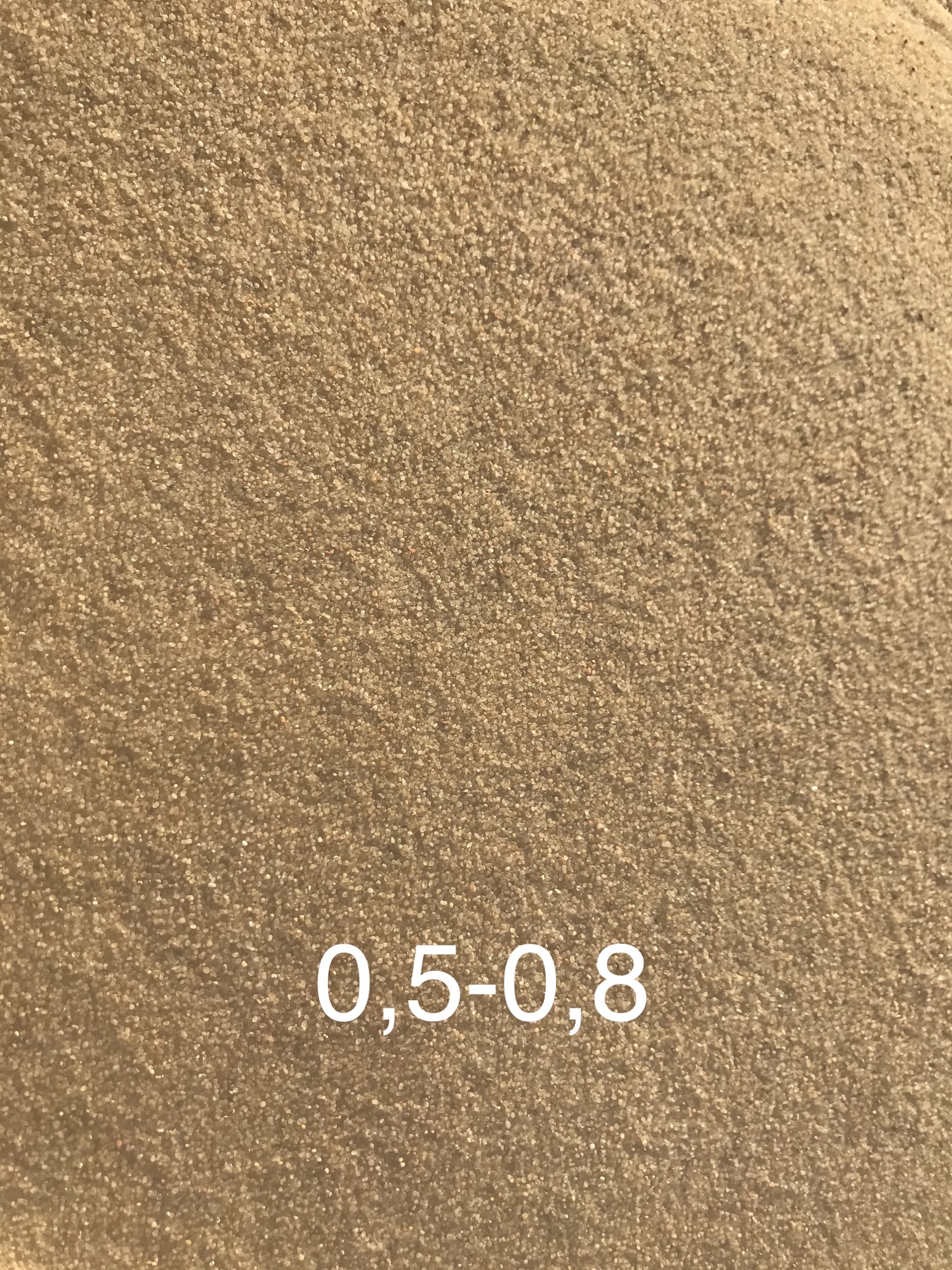 Jasny, drobnoziarnisty materiał sypki o frakcji 0,5-0,8 mm, jednolita tekstura.