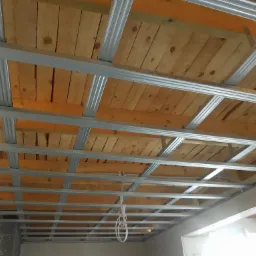 Stelaż sufitowy z profili metalowych pod drewnianym stropem, przygotowany do montażu okładziny.