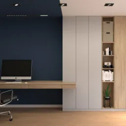 Nowoczesne biuro domowe z drewnianym biurkiem, krzesłem obrotowym na kółkach, zabudowaną szafą z półkami wypełnionymi książkami i dekoracjami, oświetleniem punktowym i ścianą w kolorze granatowym.