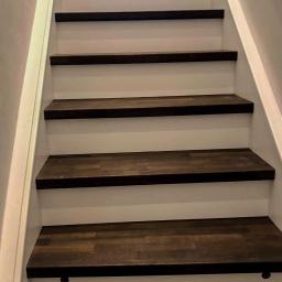 MMK Marcel Pieczka - Schody drewniane z ciemnymi stopniami i białymi podstopnicami, widoczne okrągłe zaślepki w stopnicach.