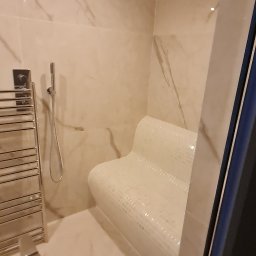 Mateusz Świeczkowski - Wykończona sauna z mozaikowym siedziskiem, chromowanym grzejnikiem drabinkowym i deszczownicą, wykończona marmurkowymi płytkami.