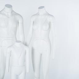 IN2IT Studio - Trzy białe, minimalistyczne manekiny: męski, damski i dziecięcy, z zaznaczonymi liniami kroju, ustawione na białym tle.