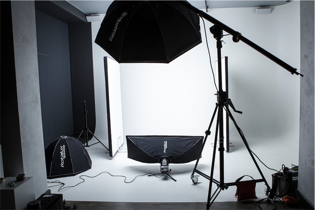 Studio fotograficzne z oświetleniem Elinchrom i Rotolux, tłem i statywami, przygotowane do sesji.
