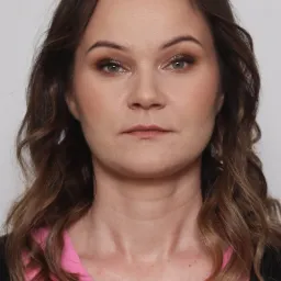 Portret kobiety z delikatnym makijażem dziennym, uwydatnione brązowe cienie na powiekach i subtelny róż na policzkach, włosy brązowe z refleksami.