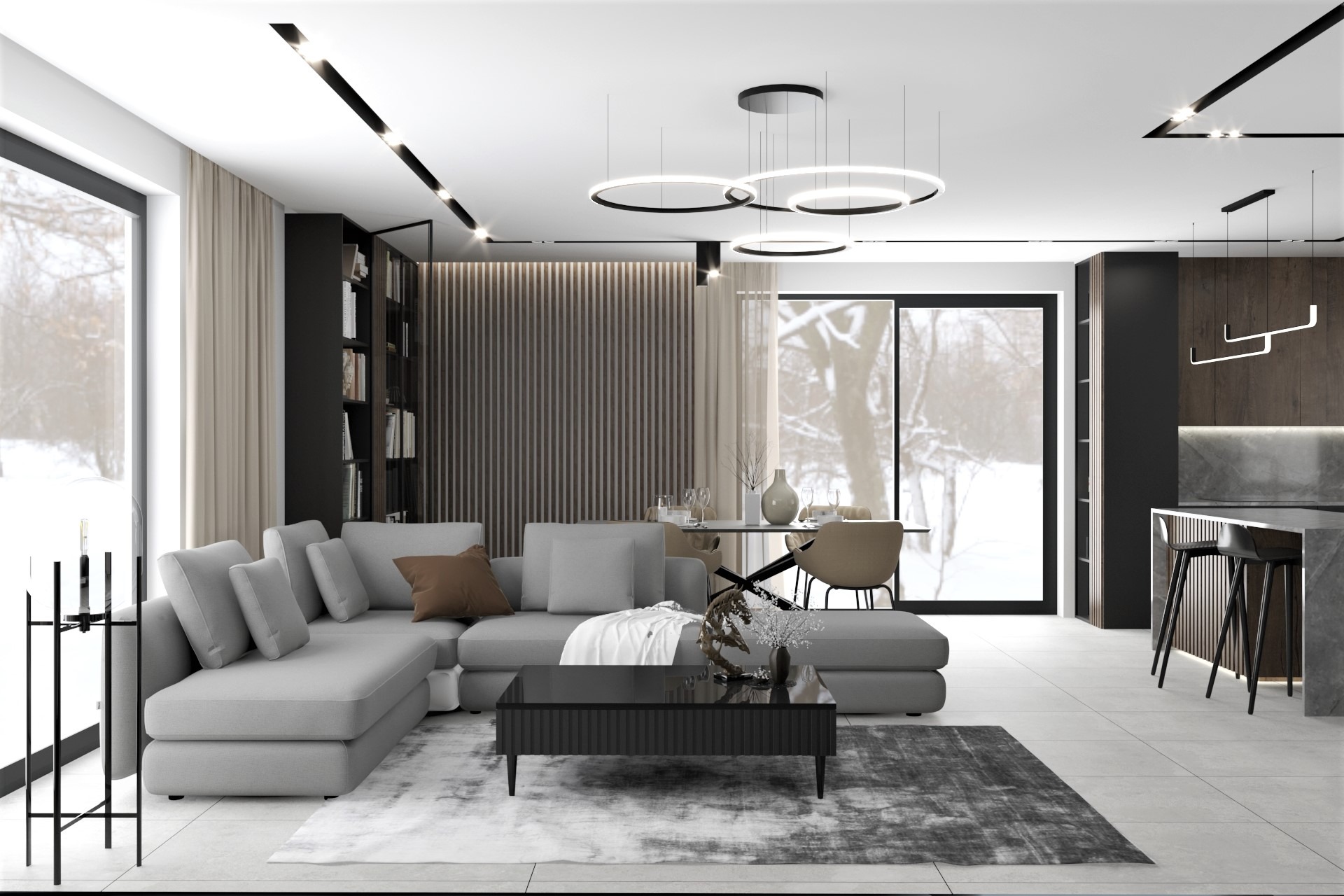 Nowoczesny salon z szarą sofą narożną, czarnym stolikiem kawowym z dekoracjami, okrągłymi lampami sufitowymi i widokiem na ośnieżony krajobraz za oknem.