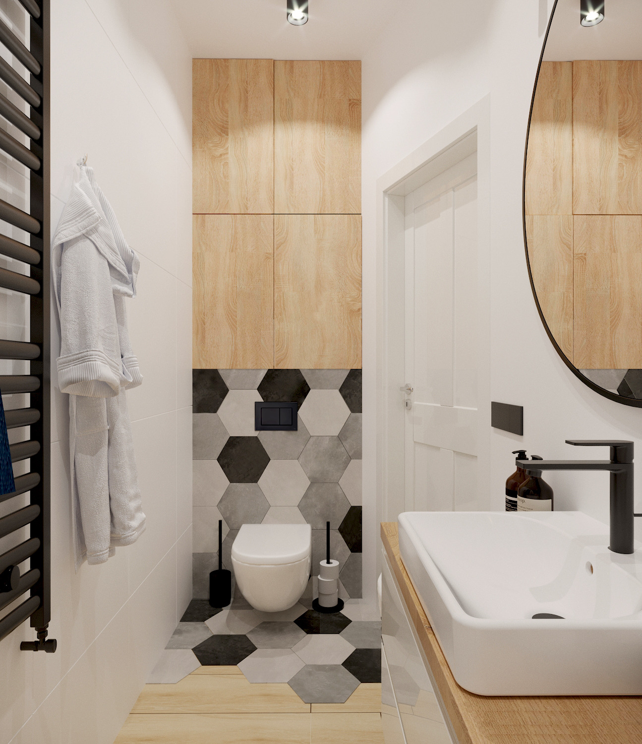 Nowoczesna łazienka z heksagonalnymi płytkami w odcieniach szarości i czerni, drewnianymi szafkami nad toaletą, owalnym lustrem i czarną armaturą.