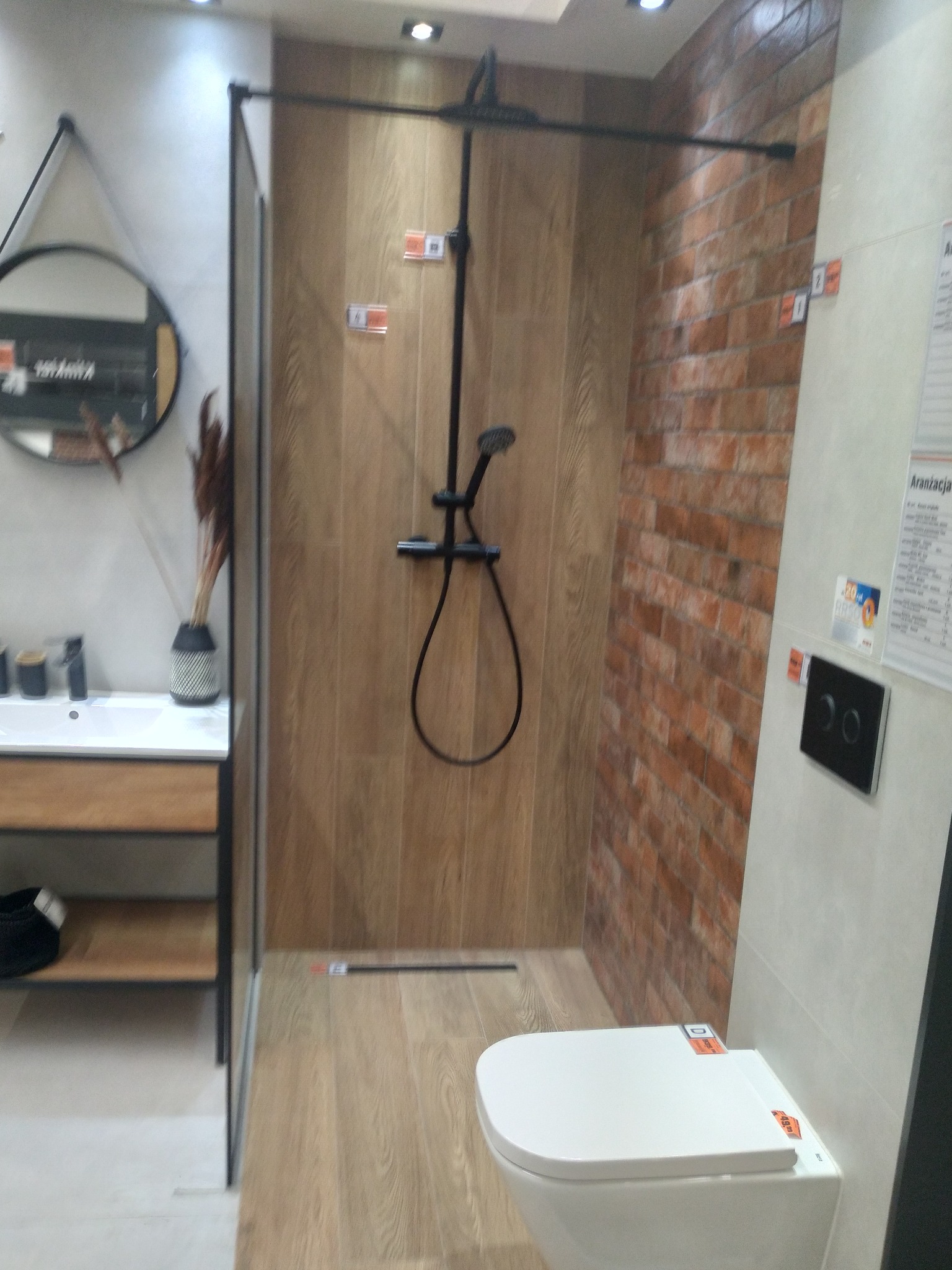 Nowoczesna aranżacja łazienki w Suchym Dębie z kabiną prysznicową typu walk-in, deszczownicą w kolorze czarnym, umywalką nablatową z szafką i toaletą w zabudowie.