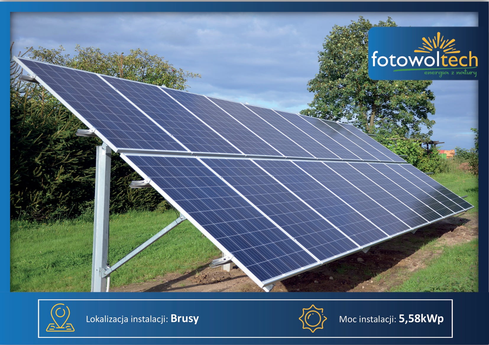 Instalacja paneli słonecznych na trawiastym terenie, widoczne srebrne konstrukcje wsporcze, w tle drzewa i błękitne niebo z chmurami.