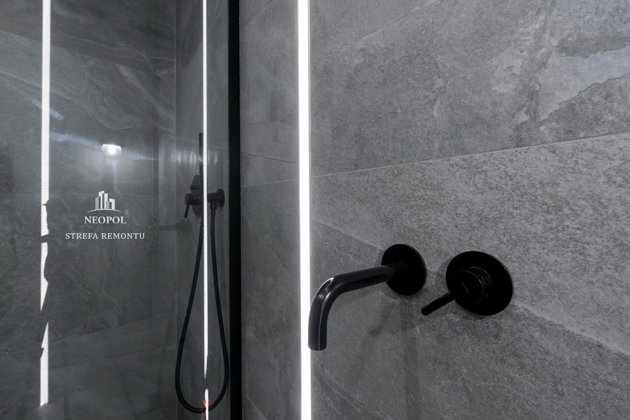 Szare płytki imitujące kamień w kabinie prysznicowej z czarną armaturą i podświetleniem LED, widoczne logo 'NEOPOL Strefa Remontu' na szklanej ściance.