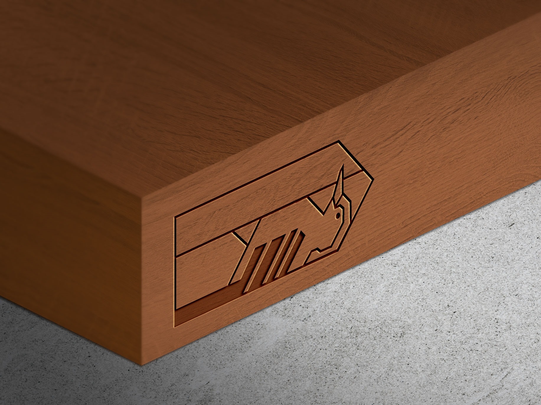 Wytłoczony, geometryczny logotyp zwierzęcia na krawędzi drewnianego bloku z widoczną teksturą drewna, leżącego na szarej, teksturowanej powierzchni.