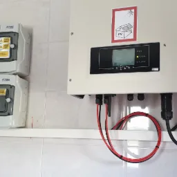 Rozdzielnice PV-DC i PV-AC oraz falownik z widocznym wyświetlaczem i okablowaniem, zamontowane na kafelkowanej ścianie.