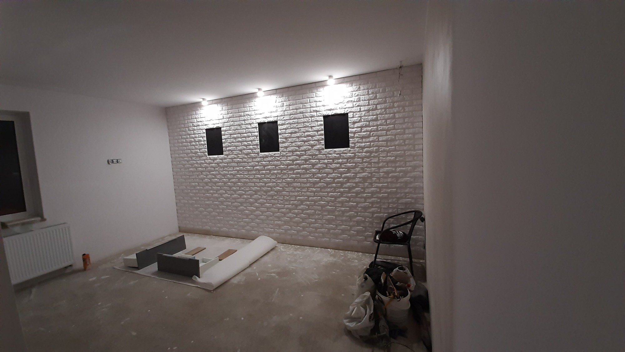 Układanie cegły gipsowej z pozostawieniem 'okienek' w głębi na zdjęcia.