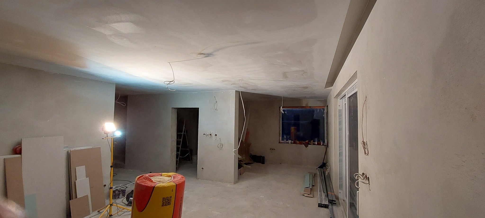 Wnętrze mieszkania w Częstochowie w trakcie szpachlowania ścian i sufitu, widoczne przygotowane płyty gipsowe, lampa budowlana i instalacja elektryczna.