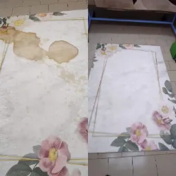 Dzielone zdjęcie dywanu przed i po czyszczeniu, widoczne plamy i efekt po usunięciu zabrudzeń, dywan z motywem kwiatowym i złotą ramką leży na podłodze z płytek.