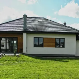 Dom parterowy z keramzytu 110 m2, z garażem, dach wielospadowy, widok od strony ogrodu.