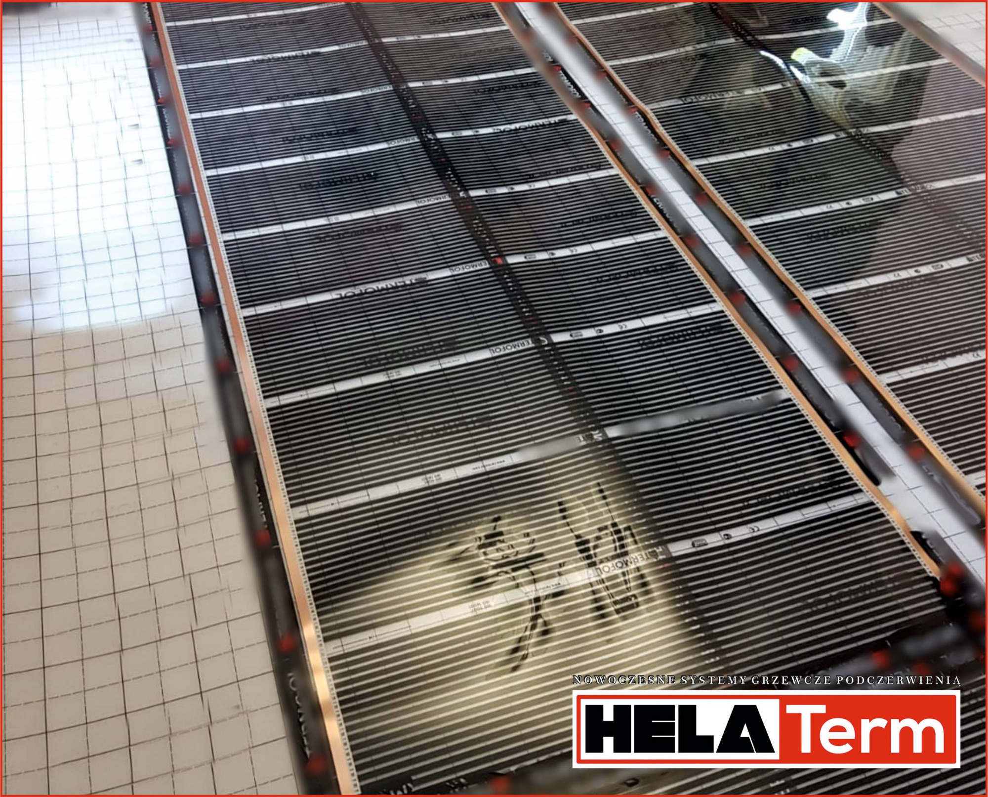 Rozłożona mata grzewcza podłogowa z widocznymi elementami grzejnymi i folią izolacyjną w kratkę, z logo producenta Hela Term w prawym dolnym rogu.
