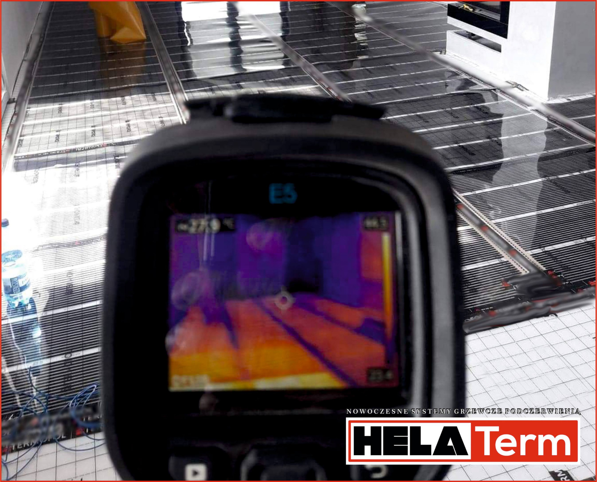 Termowizja instalacji ogrzewania podłogowego, widok z bliska na ekran kamery termowizyjnej Flir E5, na tle rozłożone maty grzewcze, logo Hela Term.