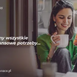 Uśmiechnięta kobieta w zielonym swetrze siedzi przy oknie z laptopem, pije kawę z białego kubka i przegląda pomarańczowy smartfon, logo firmy finansowej w lewym górnym rogu.