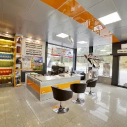 Wnętrze biura firmy w Krzepicach z ekspozycją blach trapezowych w różnych kolorach, wzorniki dachówek przy oknie i nowoczesne krzesła dla klientów.