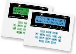 Dwa panele sterowania systemem zabezpieczeń firmy Safer z wyświetlaczami LCD, prezentujące menu opcji użytkownika i kasowania, z klawiaturą numeryczną i strzałkami nawigacyjnymi, umieszczone...
