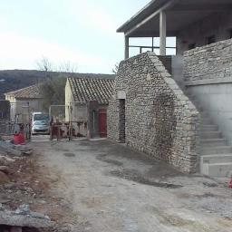 Walerczak Marcin - Budynek w trakcie remontu z kamienną elewacją i betonowymi schodami zewnętrznymi, widoczne gruzy i samochód w tle.