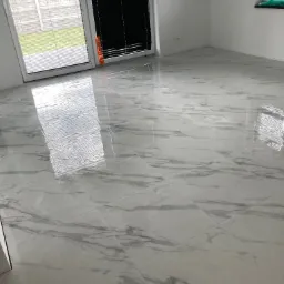 Błyszcząca, biała podłoga wyłożona płytkami imitującymi marmur, widok z perspektywy podłogi, z oknami w tle