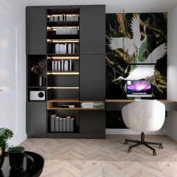 Conceptbe Pracownia Architektury Wnętrz - Nowoczesny gabinet z biurkiem wbudowanym w czarny regał, krzesło obrotowe z jasną tapicerką, ściana ozdobiona obrazem z motywem żurawi, parkiet w jodełkę.