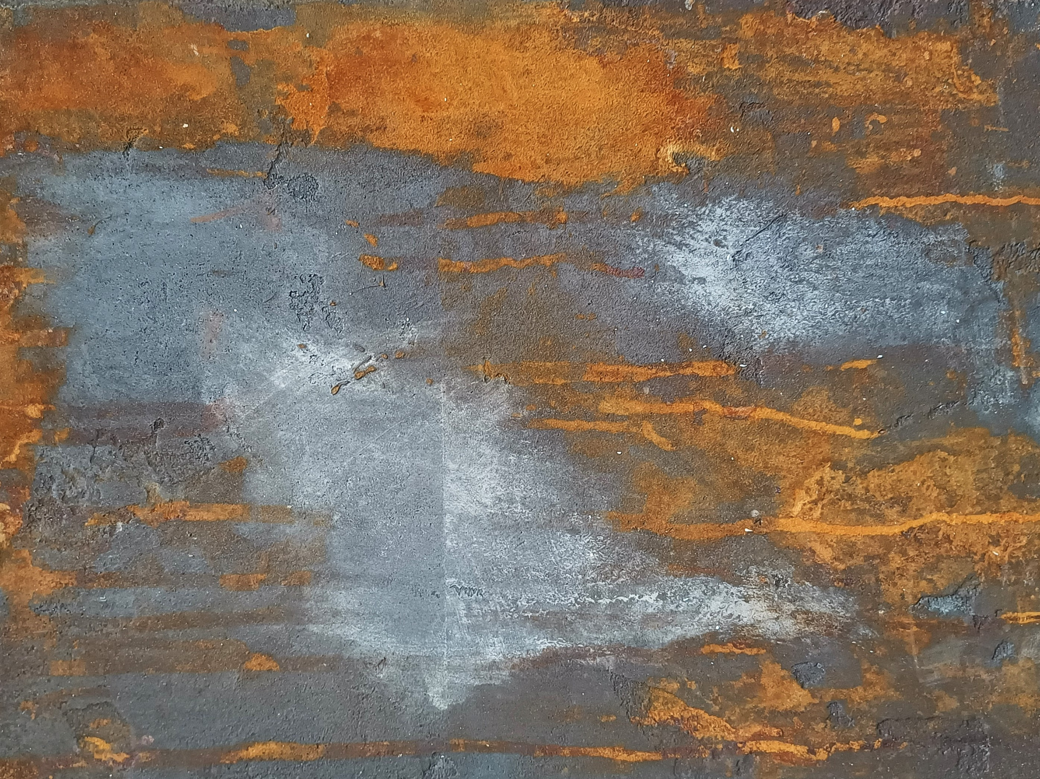 Fragment zardzewiałej metalowej powierzchni z śladami białej farby, tworzący abstrakcyjny wzór.