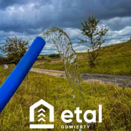 Strumień krystalicznie czystej wody wypływa z niebieskiego węża na tle zielonej trawy i pochmurnego nieba. Widoczne logo firmy 'etal ODWIERTY'.