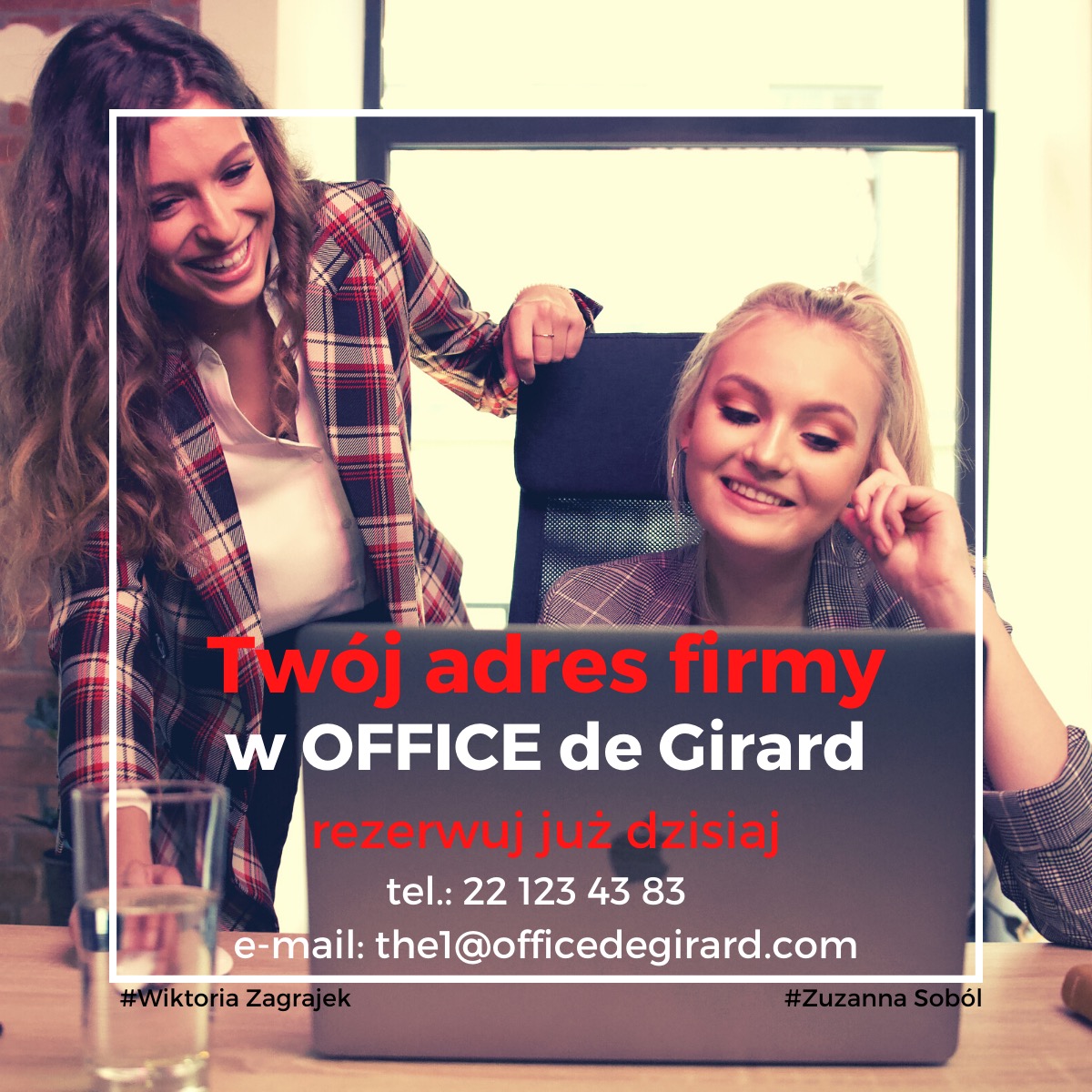 Dwie uśmiechnięte kobiety w biurze, jedna stoi opierając się o krzesło, druga siedzi przed laptopem z napisem 'Twój adres firmy w OFFICE de Girard', szklanka z wodą na biurku.
