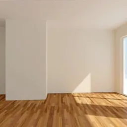 Puste, jasne pomieszczenie z drewnianą podłogą i dużym oknem przesuwnym. Ściany pomalowane na biało, wpadające światło słoneczne tworzy refleksy na podłodze.