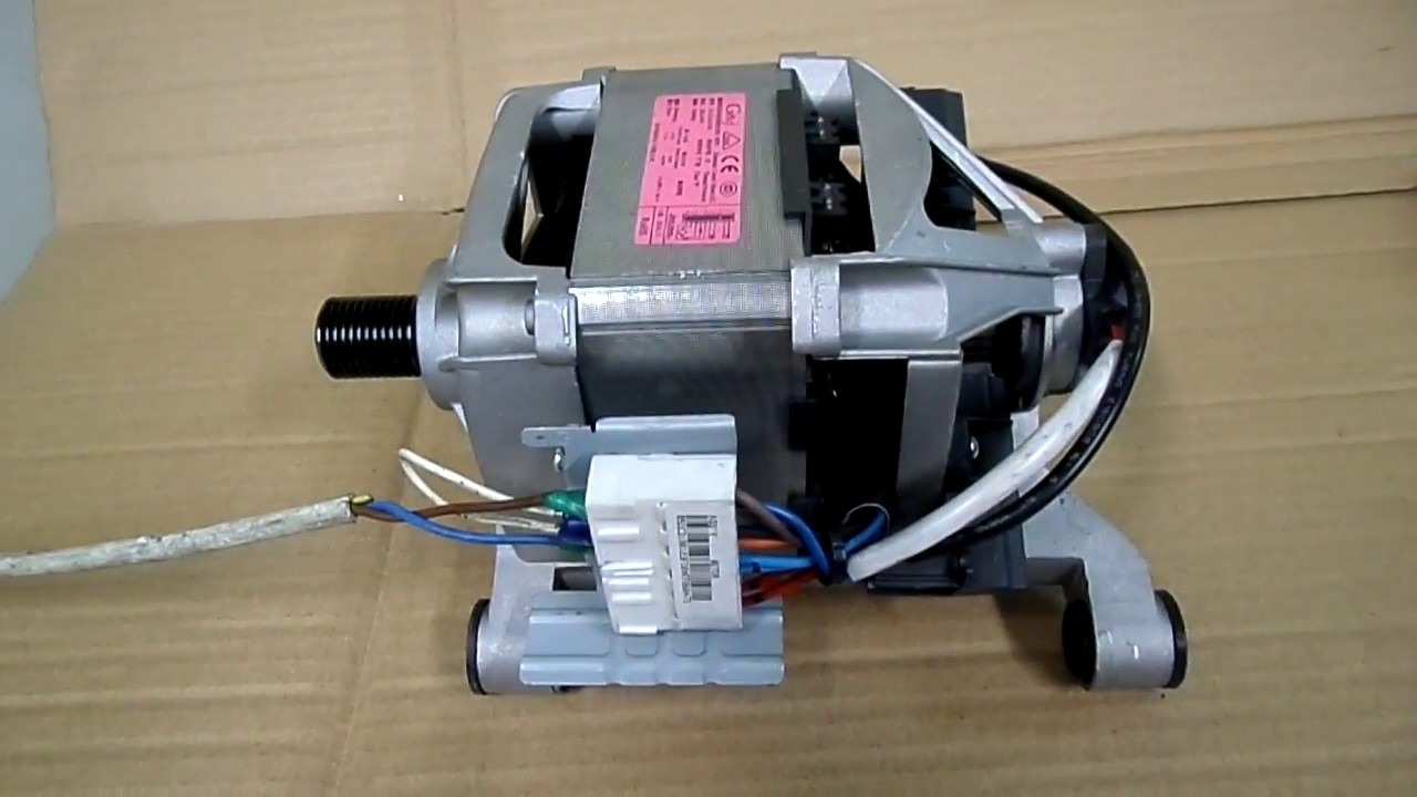 Silnik elektryczny z wystającymi przewodami i czarnym gwintowanym wałem, widoczna tabliczka znamionowa i złącze elektryczne.