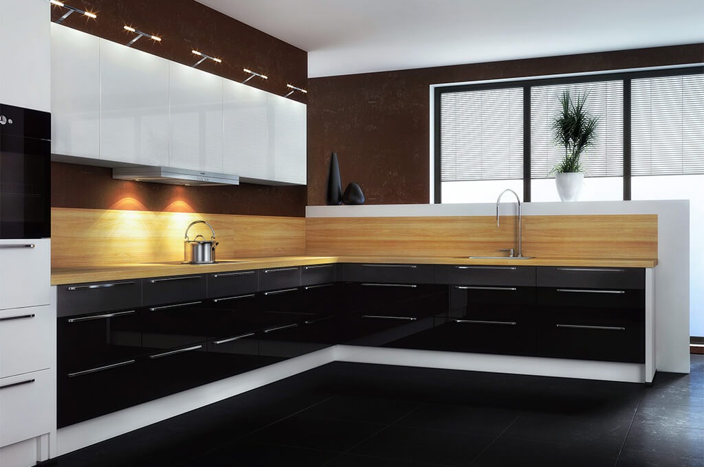 Nowoczesna kuchnia na wymiar z czarnymi, lakierowanymi frontami, drewnianym blatem i białymi szafkami wiszącymi z oświetleniem punktowym.