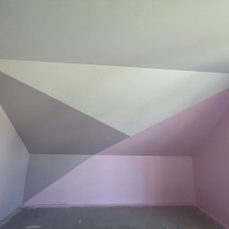 Rak-Fach Dawid Rak - Pokój na poddaszu po malowaniu ścian w geometryczne wzory w odcieniach szarości, bieli i różu. Widoczne gniazdka elektryczne i surowa podłoga.