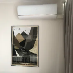 Biały klimatyzator Haier zamontowany nad oprawionym plakatem w jasnym pokoju w Radomiu, obok zasłonięte okno.