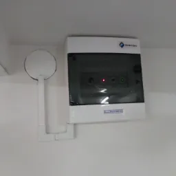 Panel sterowania z dwoma diodami LED (jedna czerwona, druga zielona) zamontowany na białej ścianie, z widocznym czujnikiem i logo firmy ElektroAqua.