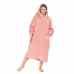 Uśmiechnięta kobieta w obszernym, różowym, pluszowym okryciu z kapturem i wzorem serc, pozująca na białym tle, z ręką w kieszeni.